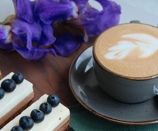 Blueberr Cinnamon Crumble flavored coffee in a cup next to some blueberry desserts